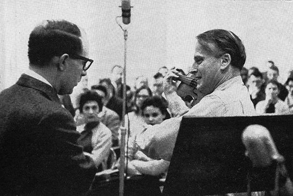 man with violin in front of crowd